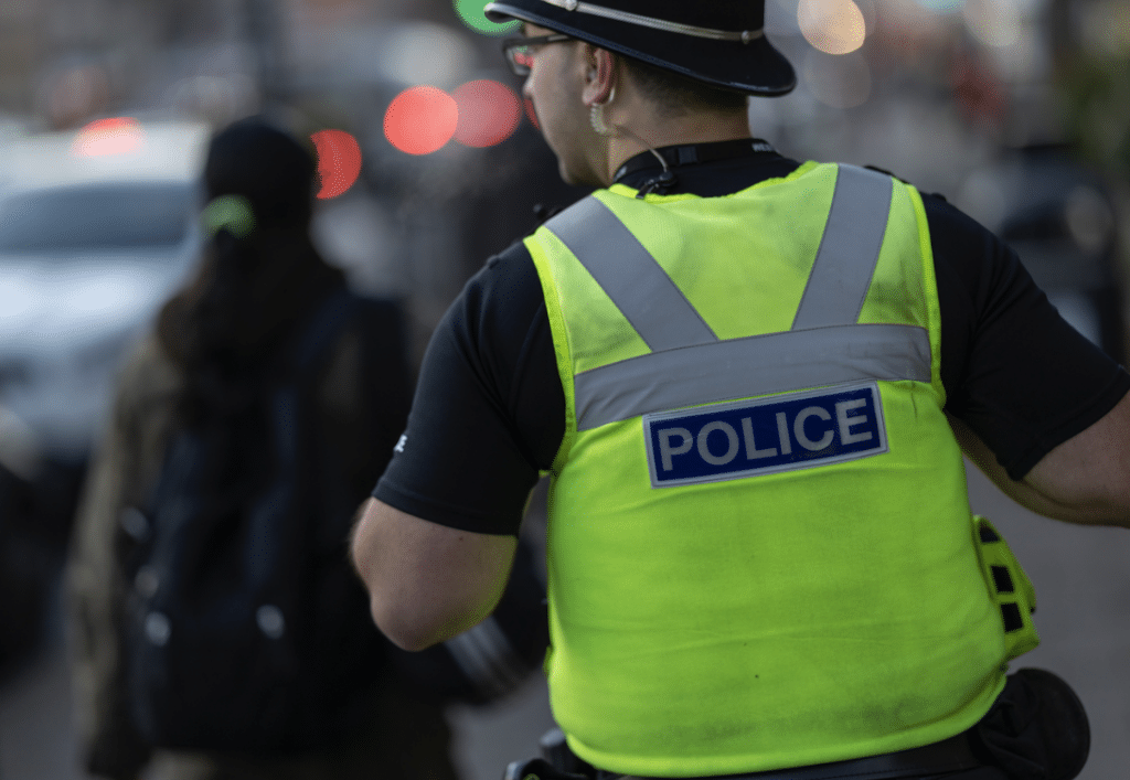 View form the back of a patrolling police officer in a high-vis vest.