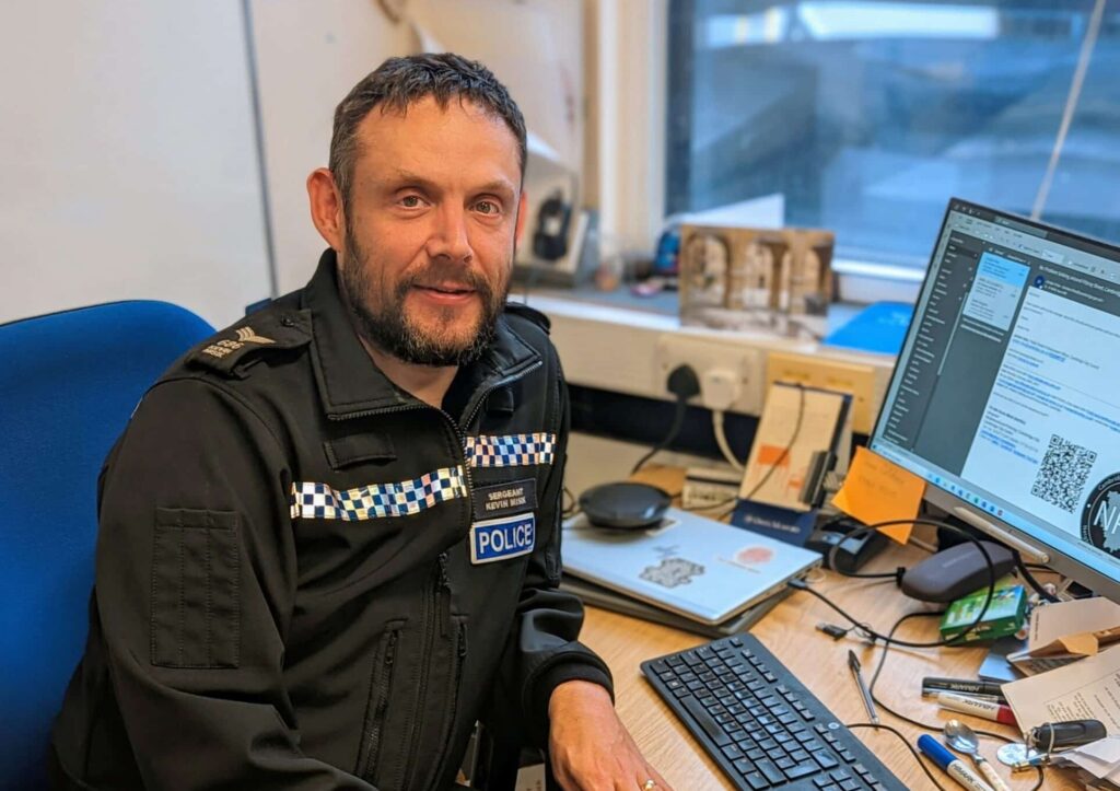 A police sergeant sitting at his desk.