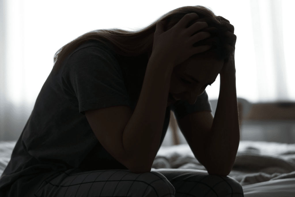 Woman holding her head in her hands in distress.