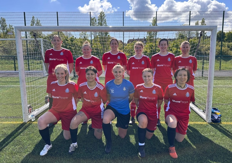 The Cambs Police FC (CPFC) women's squad pose in front of goal posts.